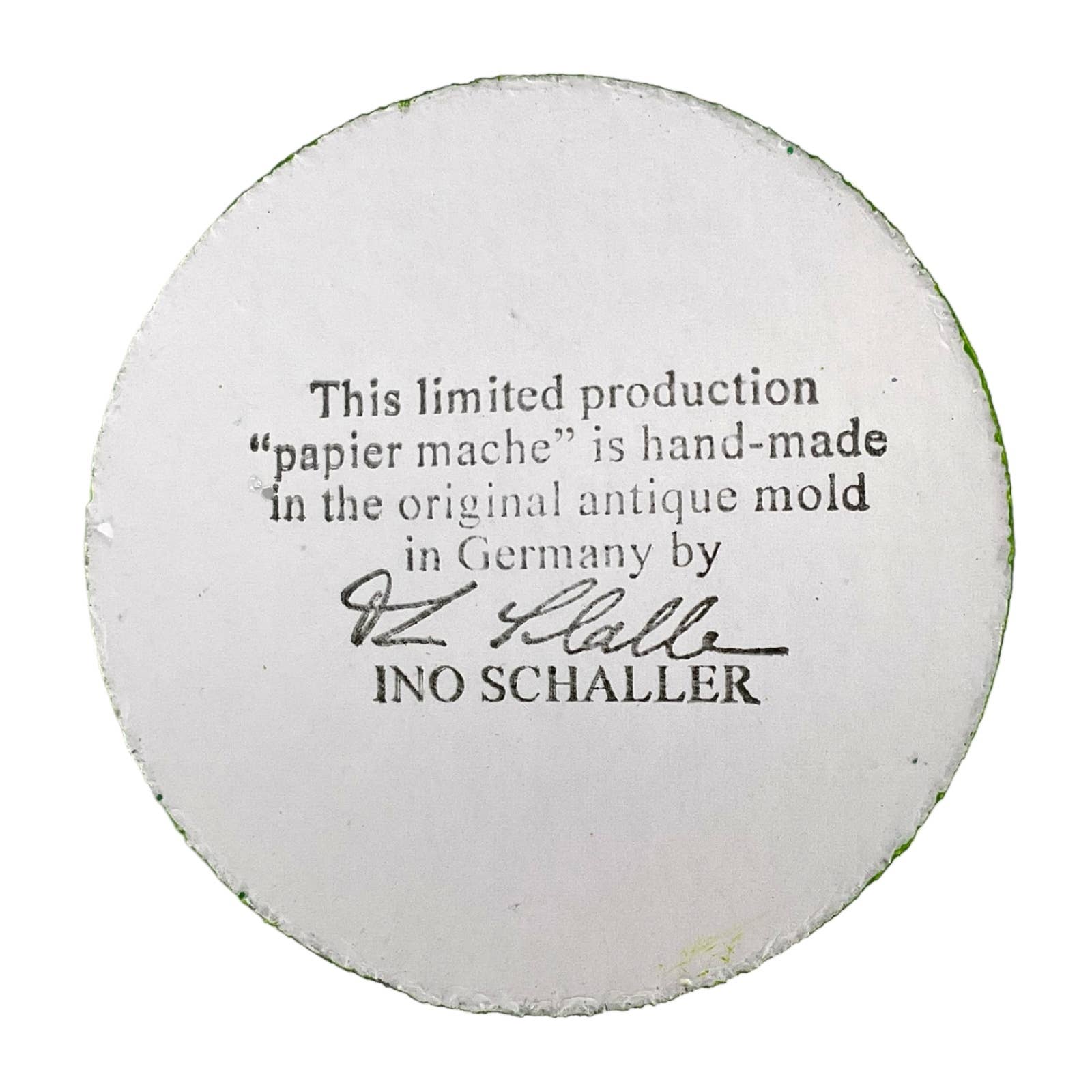 White circular papier-mâché base with black text and signature on ino schaller easter hand-painted paper rabbit