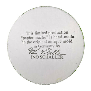 White circular papier-mâché base with black text and signature on ino schaller easter hand-painted paper rabbit
