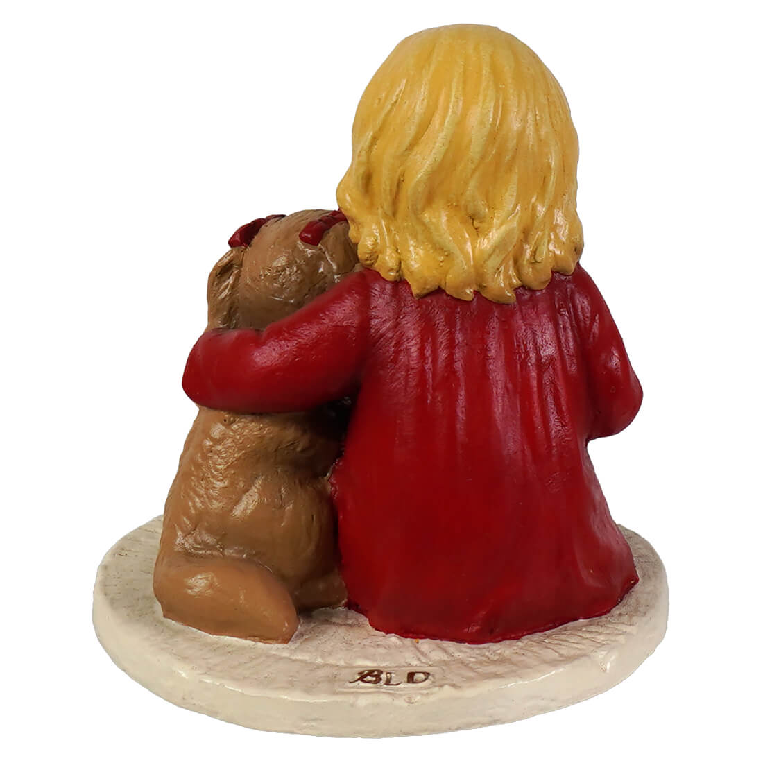 A glossy red resin bethany lowe figurine of a blonde girl hugging a brown puppy teddy bear on a white base