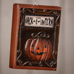 Brown bethany lowe jack o lantern book ornament with carved orange pumpkin and dark brown scrollwork frame