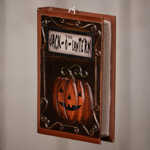 Halloween-themed bethany lowe jack o lantern book ornament with brown wood frame and black metal details