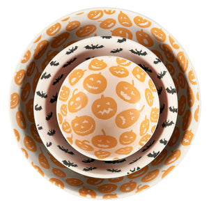 Set of three nested halloween-themed ceramic jack o lantern bowls with orange pumpkins and black bats on white background