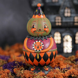 A whimsical jackie green-o-ween spooks jar pumpkin figurine with green and orange colors and a harlequin body