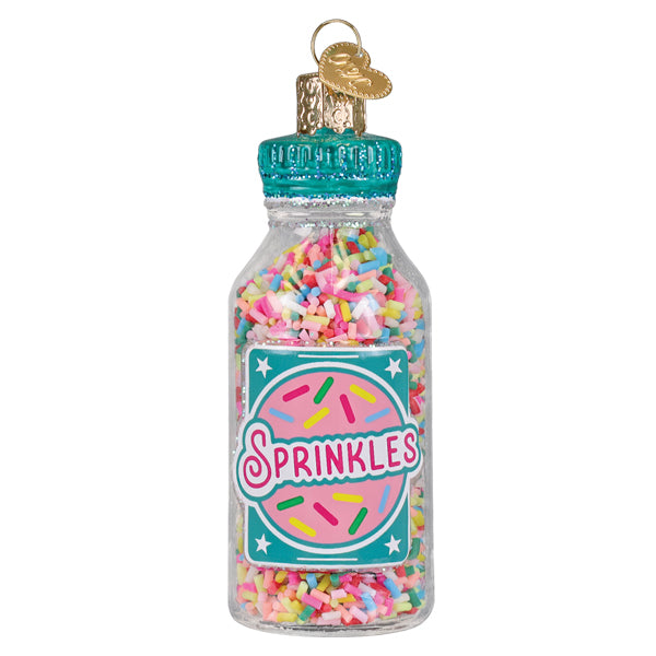A clear glass jar of sprinkles ornament filled with colorful rainbow sprinkles with teal label figural decor