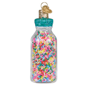 A clear glass jar of sprinkles ornament with a teal cap and gold heart tag figural decor for tree toppers or pickles ornament