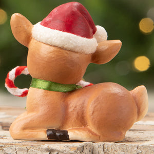 A tan resin jingle santas reindeer figurine by bethany lowe wearing a red santa hat holding a candy cane for christmas decor