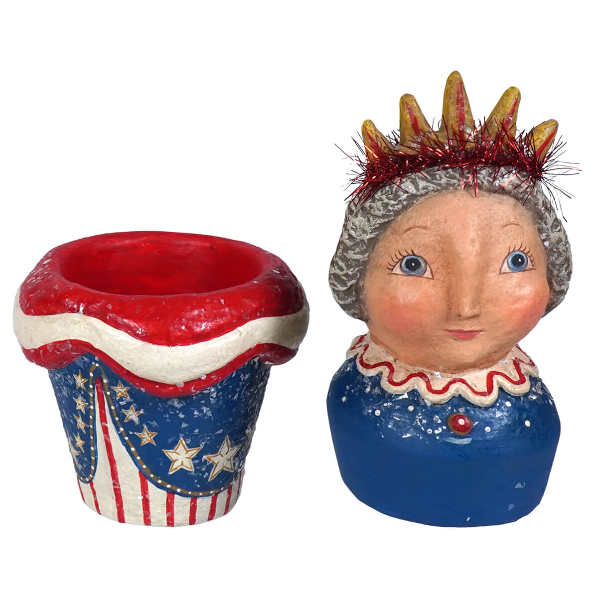 Blue ceramic figurine with crown and ruffled collar on johanna parker lady liberty container