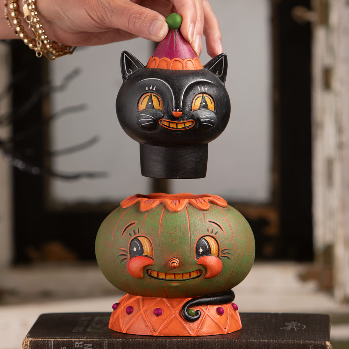 Black cat figurine with orange eyes and a jack o lantern hat from the jolly jack-a-melon stack jack spooks jar