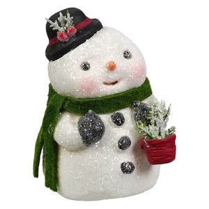 A charming white glittery bethany lowe designs snow boy christmas snowman figure with black top hat and green scarf holding a plant