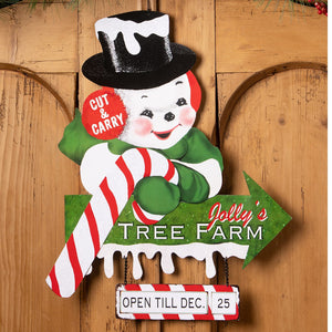 A cheerful bethany lowe wooden tree farm sign with a snowman, black top hat, green scarf, and candy cane arrow design