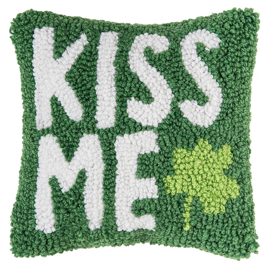 Green decorative pillow with white ’KISS ME’ text and a light green shamrock design.