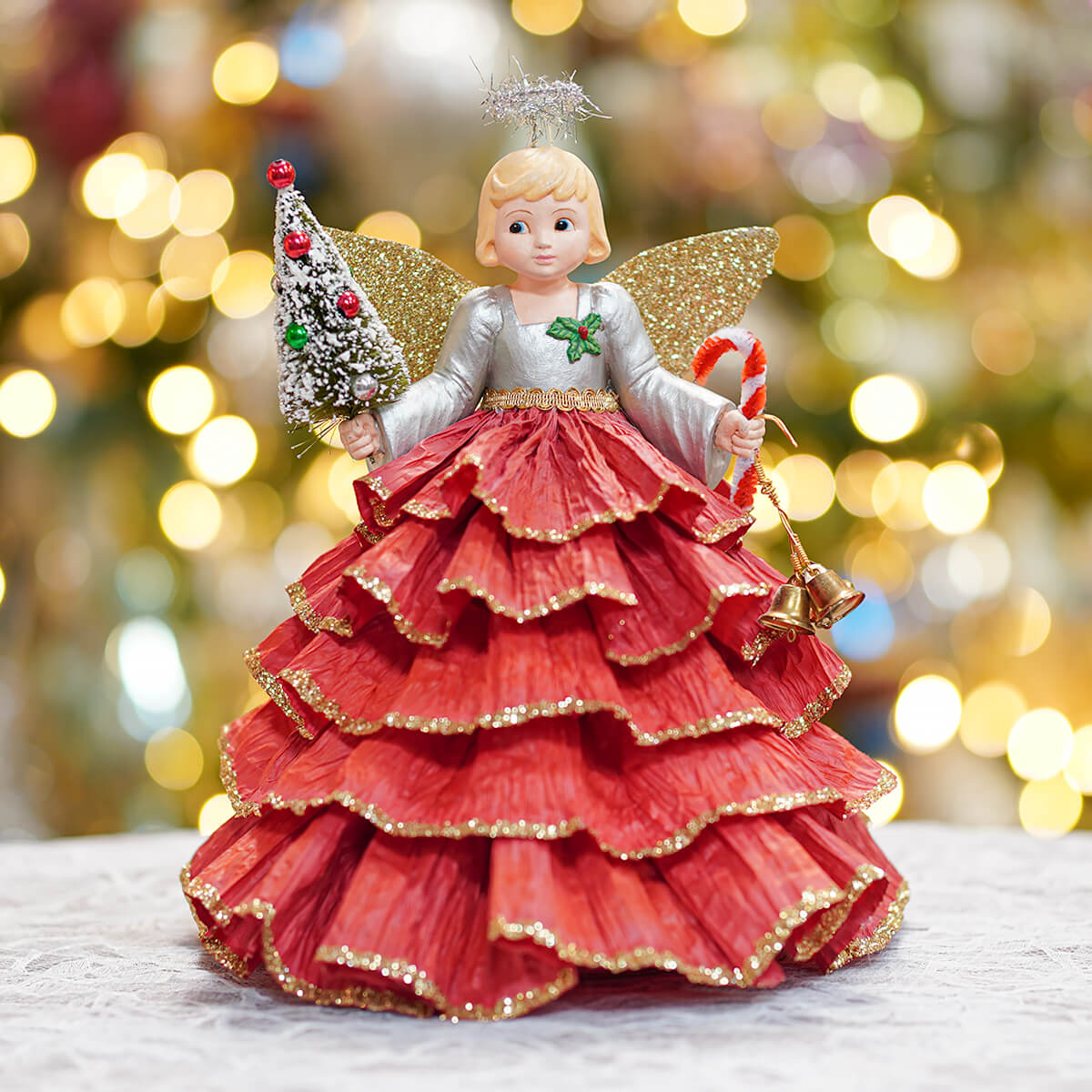 Kitschmas angel tree topper with layered red gown, glittery gold wings, holding miniature tree and candy cane, perfect earth angel tree finial