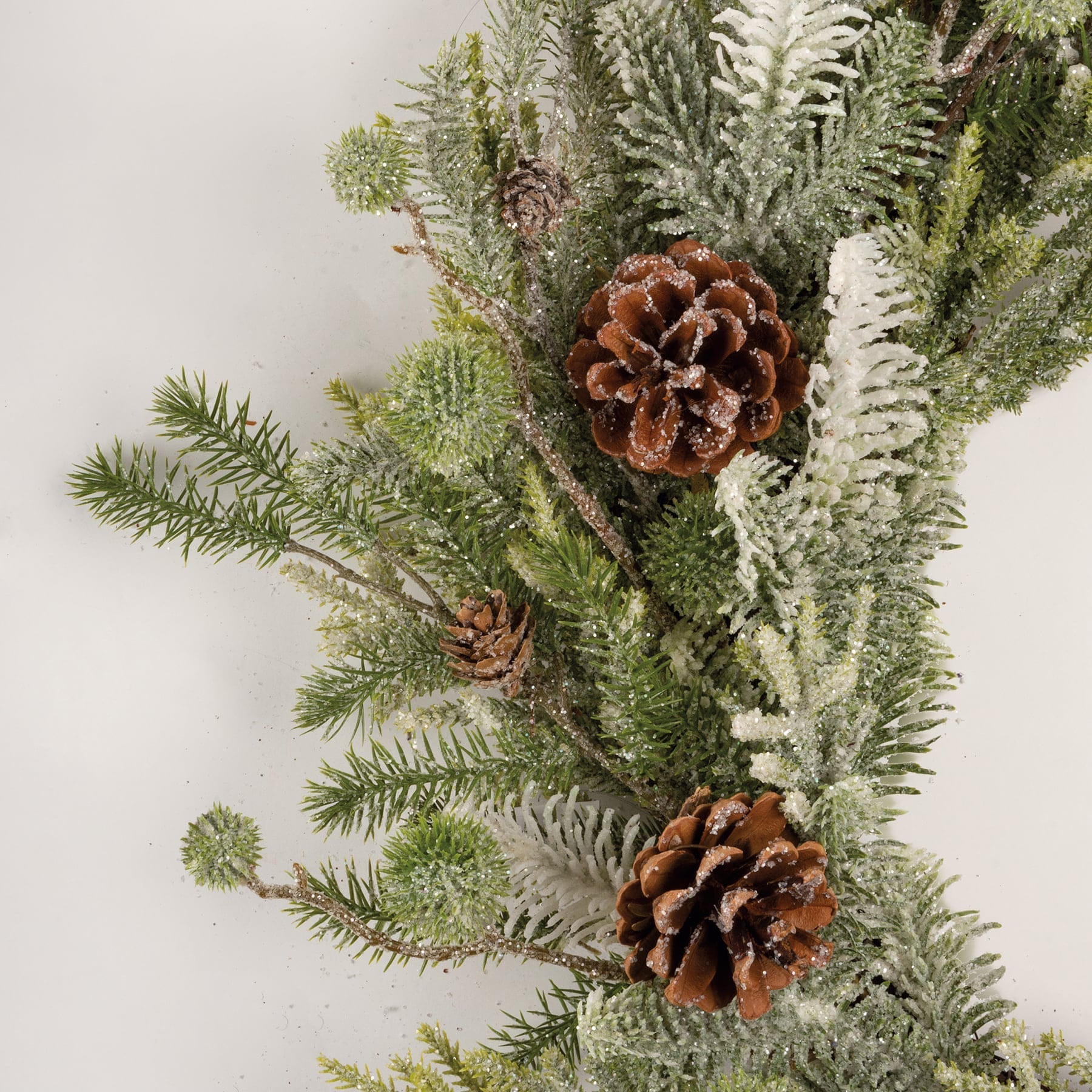 Large mixed evergreen wreath with frosty green and white artificial pine and brown pinecones for spring hanging decor