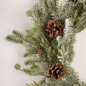 Large mixed evergreen wreath with frosty green and white artificial pine and brown pinecones for spring hanging decor