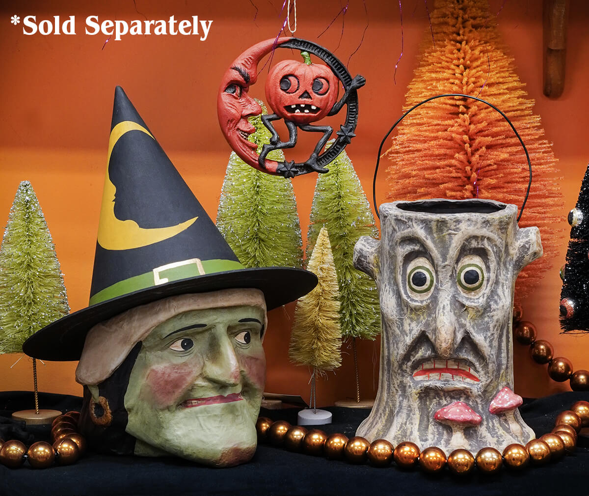 Large green faced witch candy bucket with gray textured tree trunk design and painted eyes nose and red lips for halloween