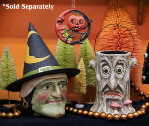 Large green faced witch candy bucket with gray textured tree trunk design and painted eyes nose and red lips for halloween