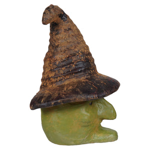A green witch head featuring a rustic dark brown and black witch hat on a greenish yellow gnome figurine perfect for halloween witches and witch decor
