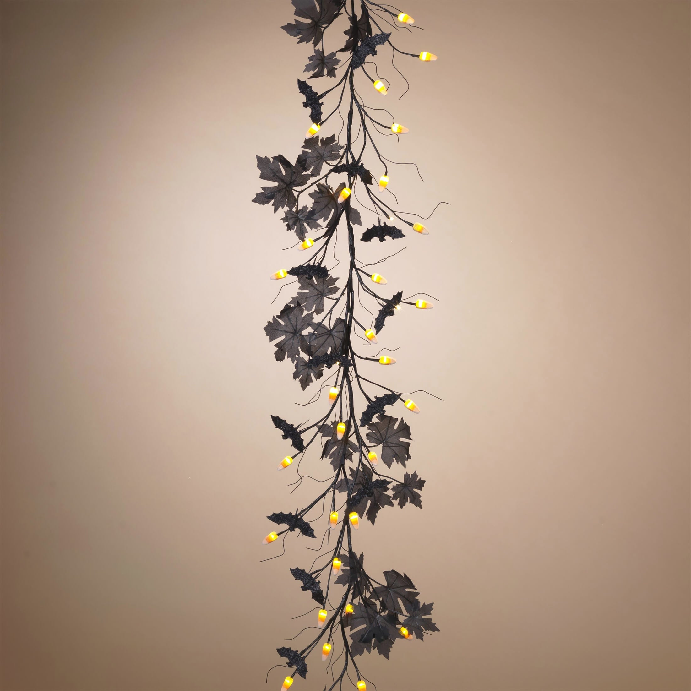 Decorative branch with dark leaves and small yellow lights.