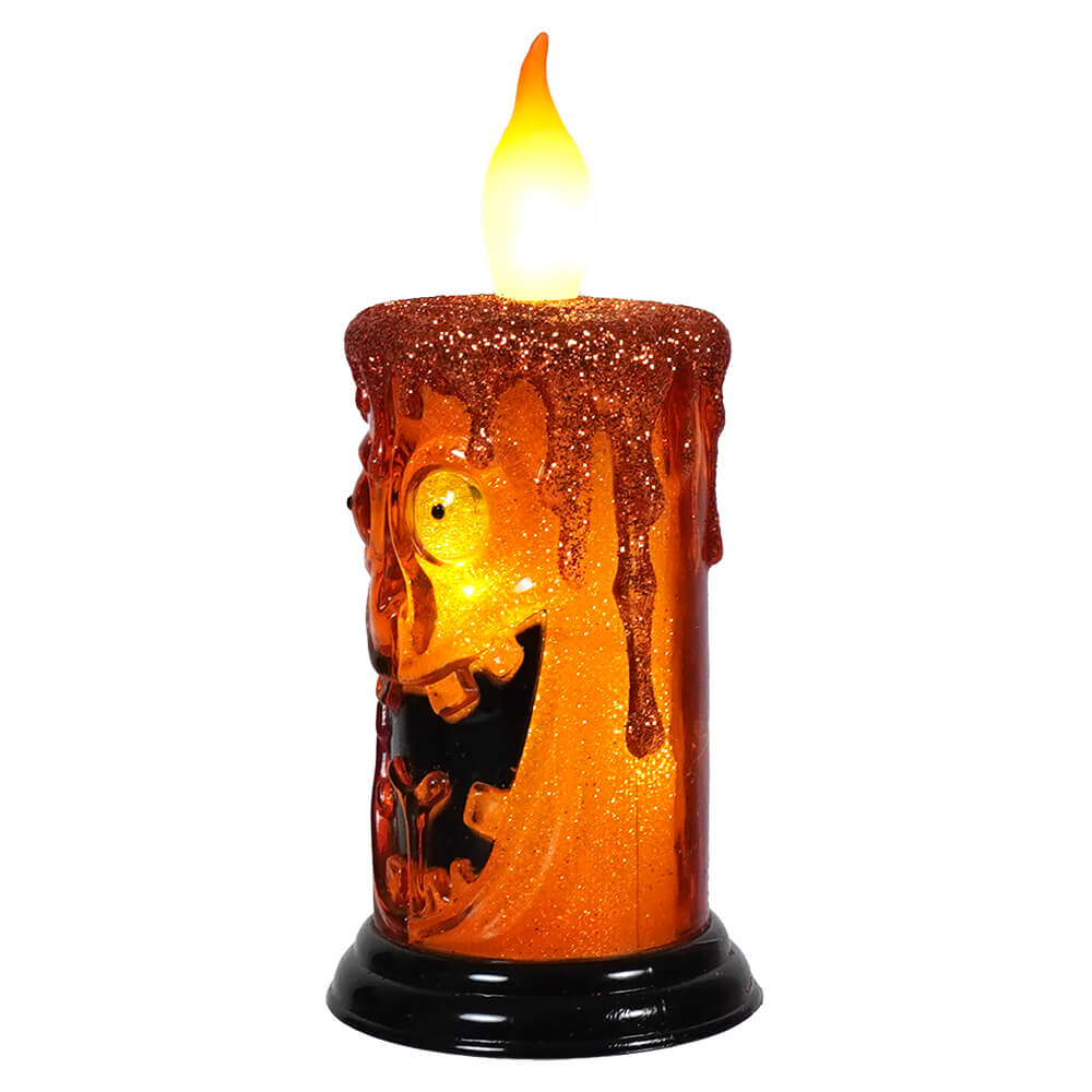 Halloween-themed decorative electric candle with glowing orange light and spooky silhouettes.