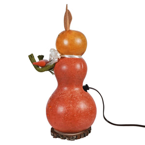A rustic orange willow bunny gourd lamp with a smaller amber bunny gourd topped with leafy carrot and silver ribbon detail