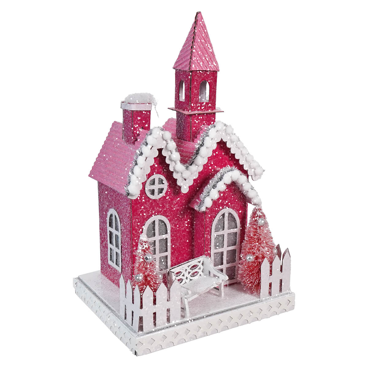 Pink glittery Christmas house decoration with snow-covered roof and white picket fence.