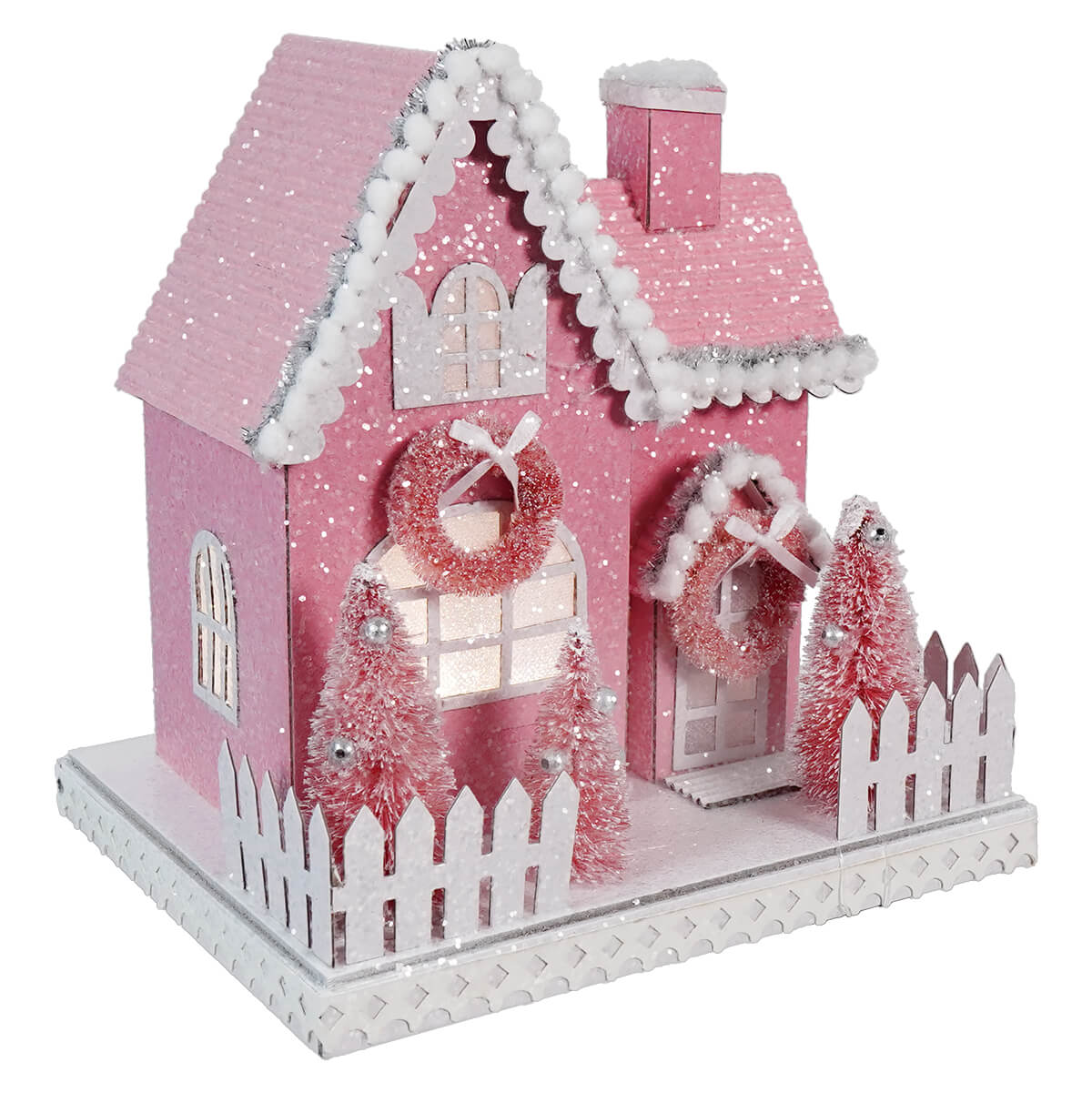 Pink miniature Christmas house with white trim and decorative wreaths.
