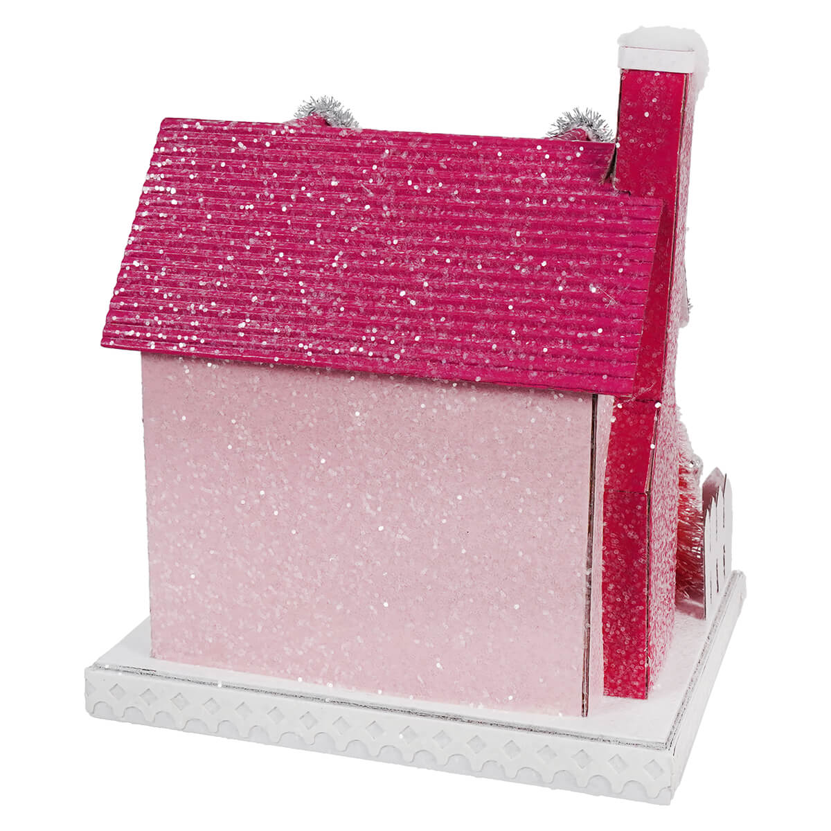 Miniature pink and red glittery house with a chimney on a white base.