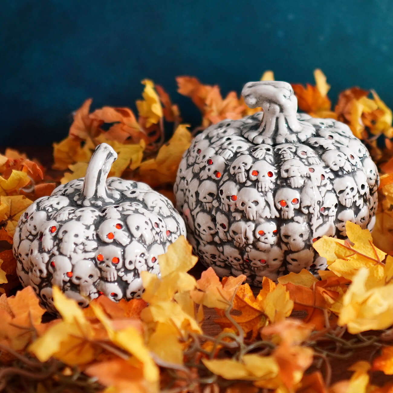 Decorative pumpkins covered in tiny sculpted skulls.