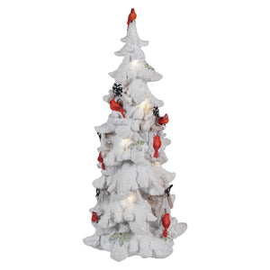 White ceramic Christmas tree decorated with red cardinals and small lights.