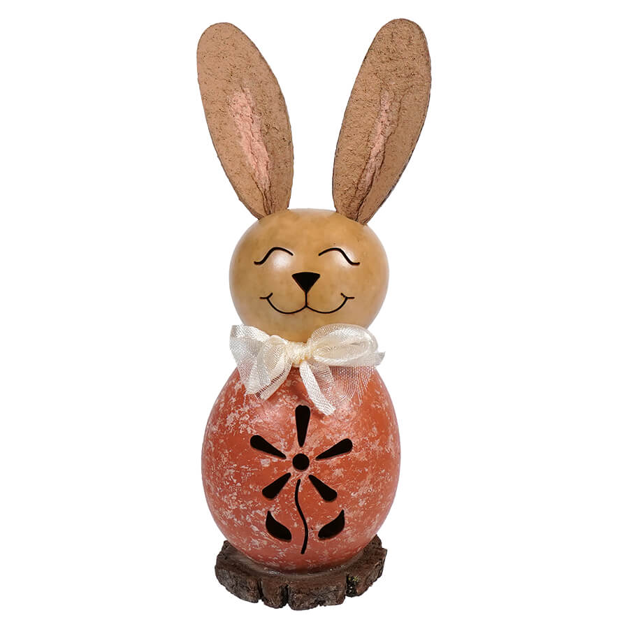 Decorative bunny figurine wearing a white bow and coral-colored outfit with cutout flower pattern.