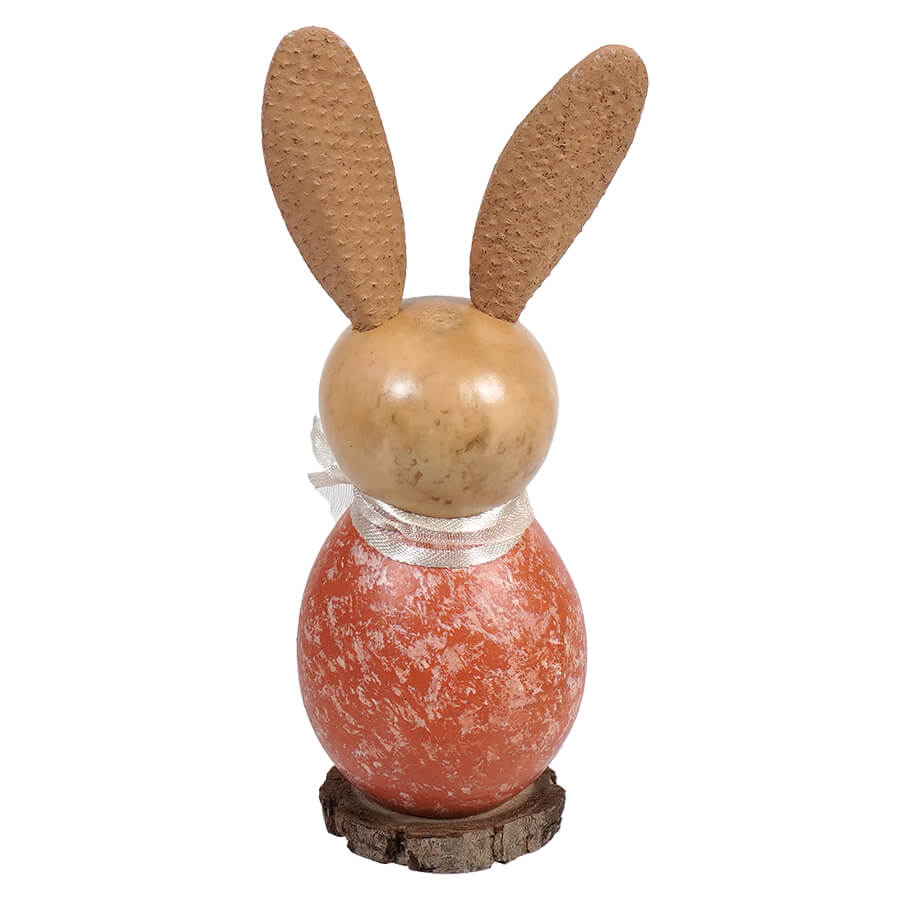 Decorative bunny figure with wooden ears and a coral-colored textured body sitting on a rustic base.