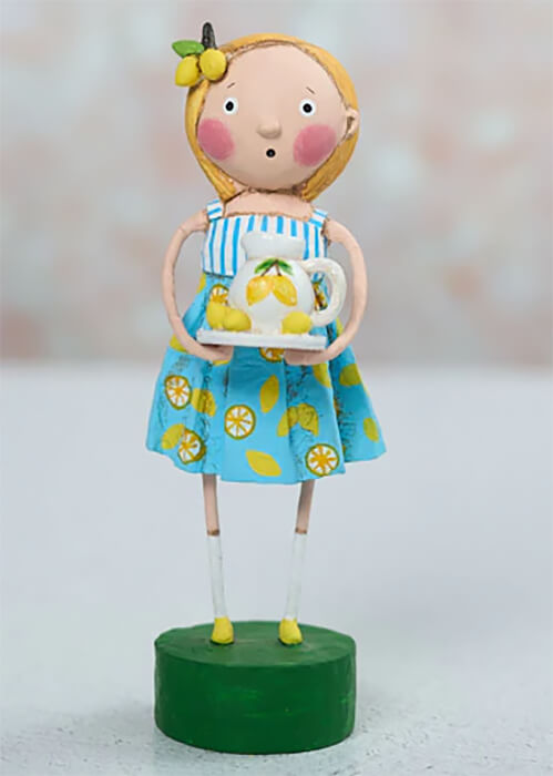 A charming lori mitchell figurine of a girl with lemon-adorned blonde hair wearing lily anne’s lemons outfit