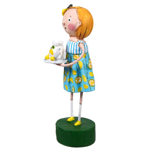 A lori mitchell figurine from lily anne’s lemons featuring a girl with orange hair in a blue lemon dress holding a white pitcher