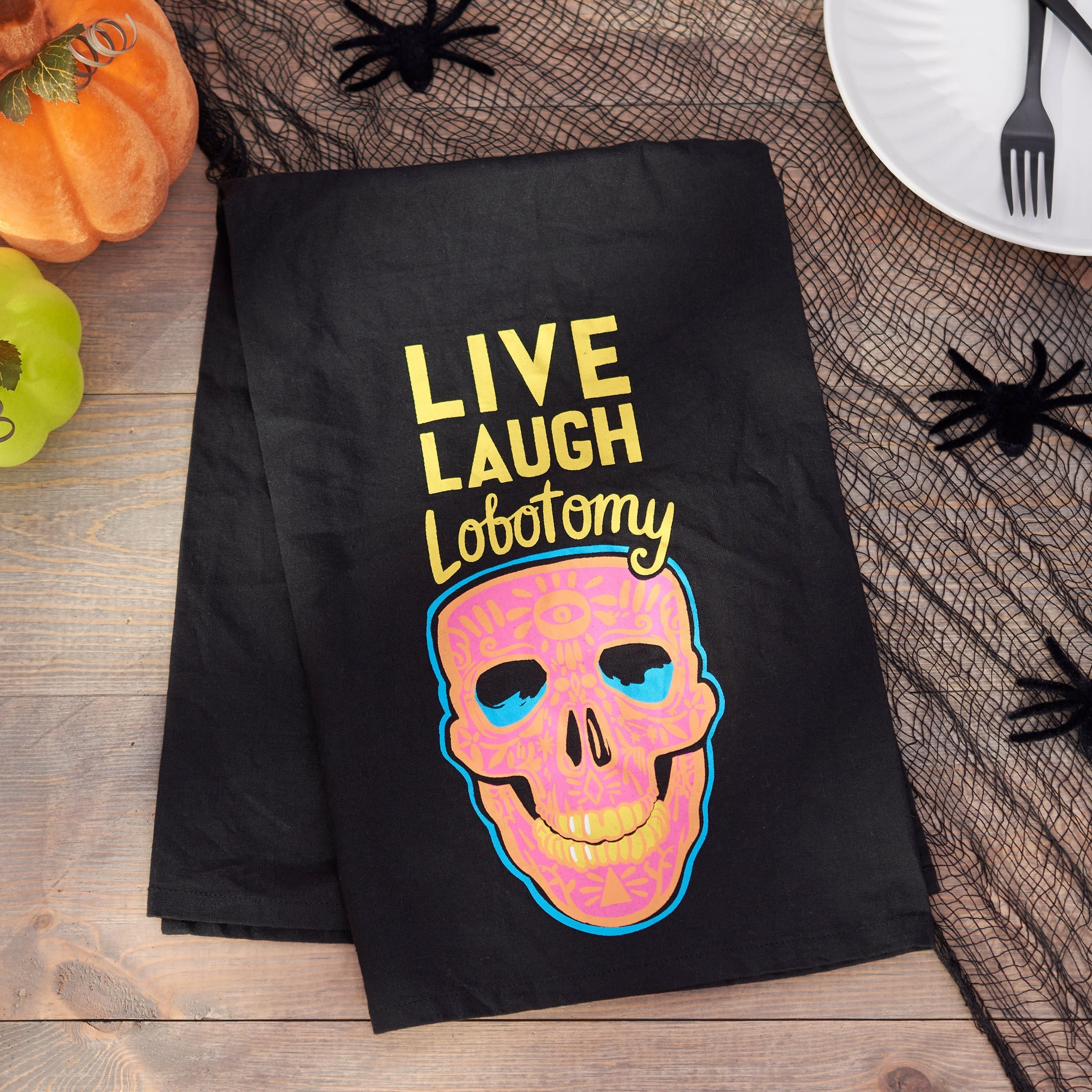 Black paper halloween party bag with colorful sugar skull and gold live laugh lobotomy text, perfect for dead & breakfast events
