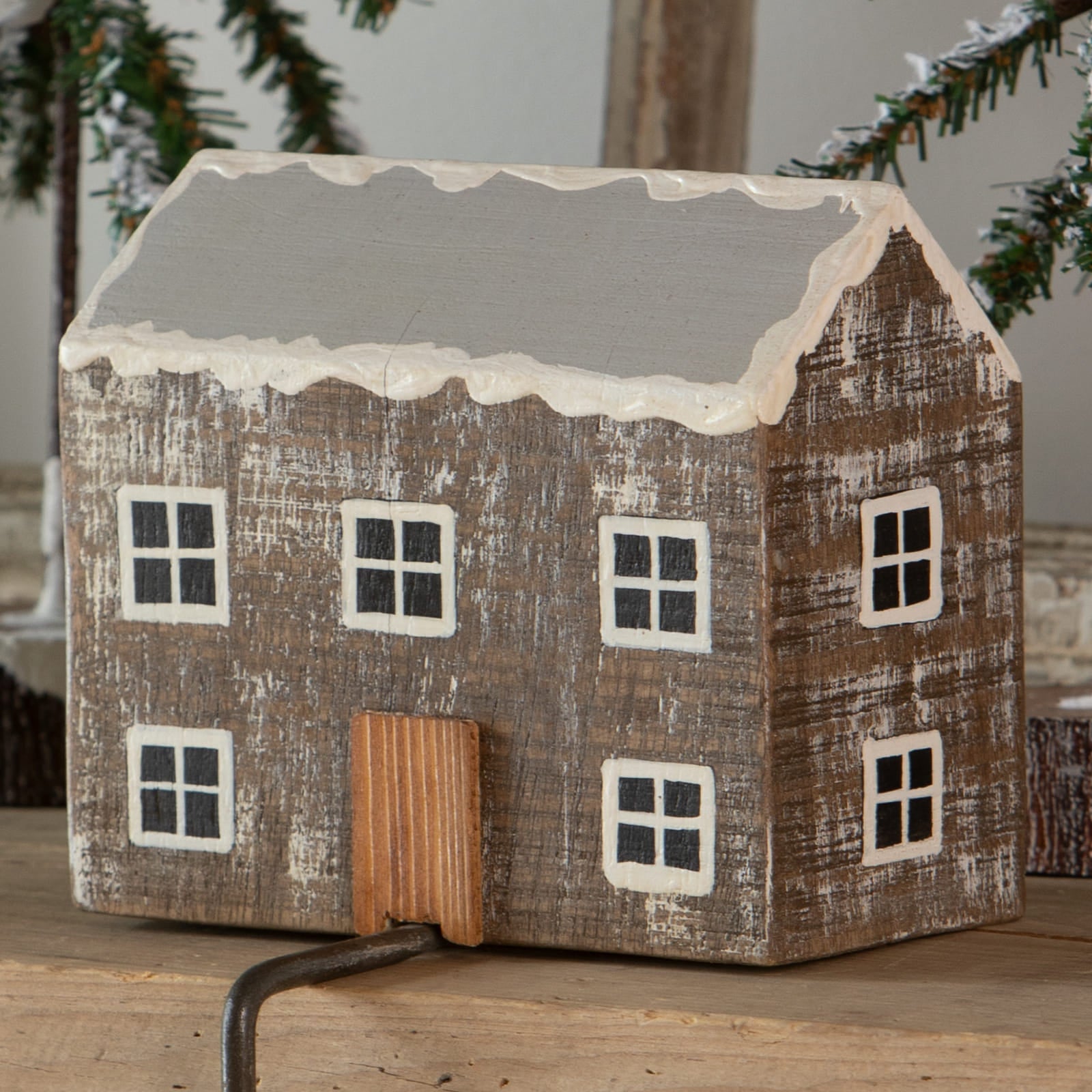 Rustic wooden log cabin stocking holder with weathered brown finish white windows and gray roof with faux snow edges