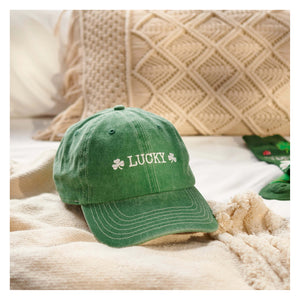 A soft green worn lucky cap with white embroidery and shamrocks perfect for st patricks day fun