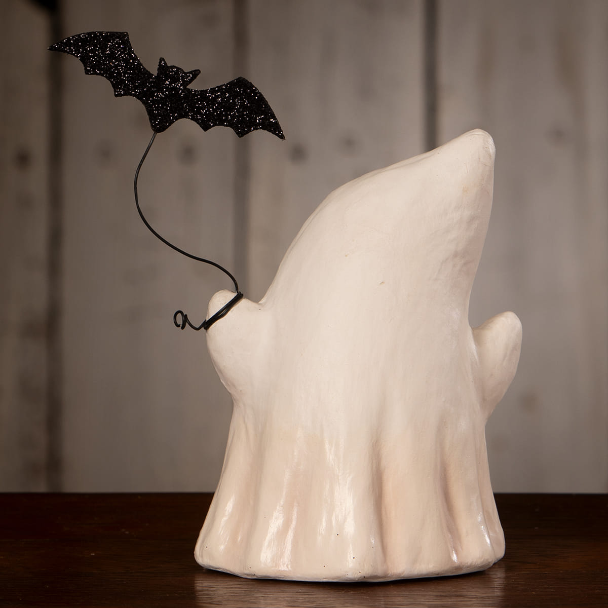 White ceramic luminary ghost figurine boo with bat featuring a black glitter bat on its shoulder