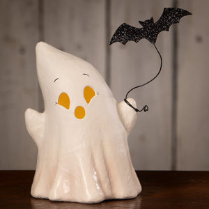 White ceramic ghost luminary boo with bat featuring yellow facial features and a black glitter bat on its shoulder