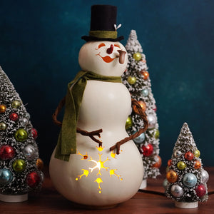 A charming meadowbrooke large snowman gourd with white ceramic, black top hat, green scarf, and illuminated star cutout