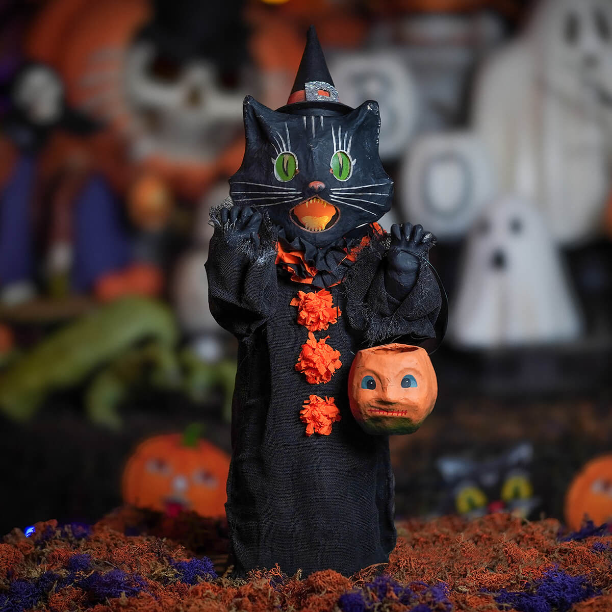 Medium scaredy cat black witch cat figurine with green eyes orange pumpkin face and black robe with orange floral accents