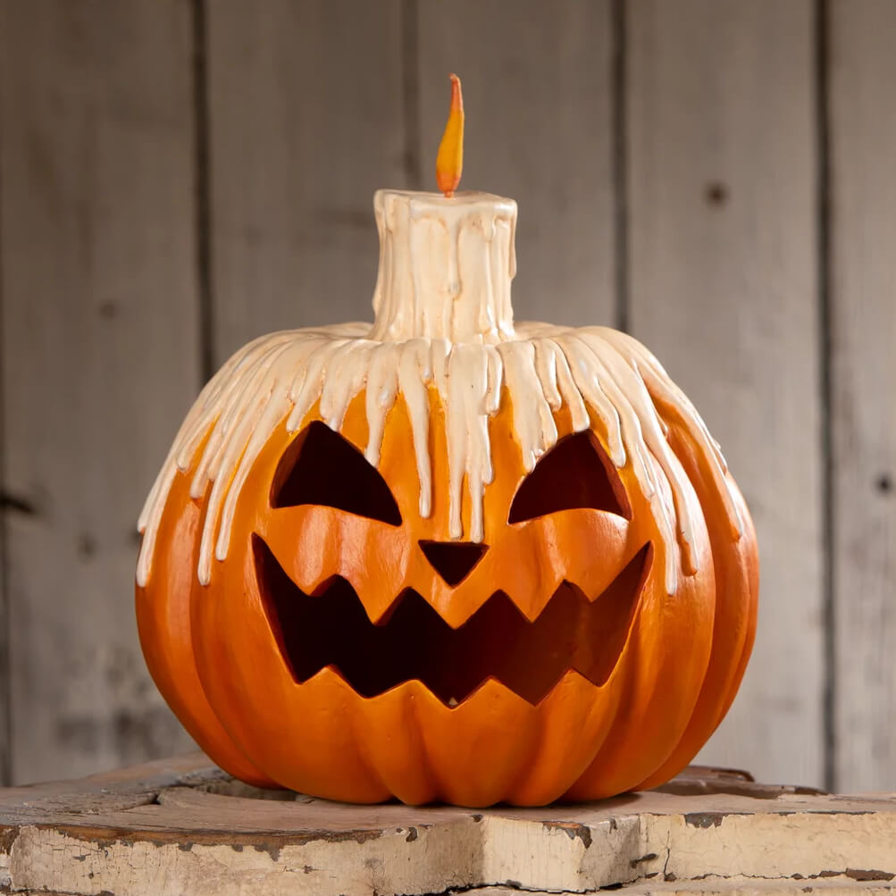 Orange midnight glow pumpkin lantern with a melting white candle on top perfect for spooky decor glow pumpkin