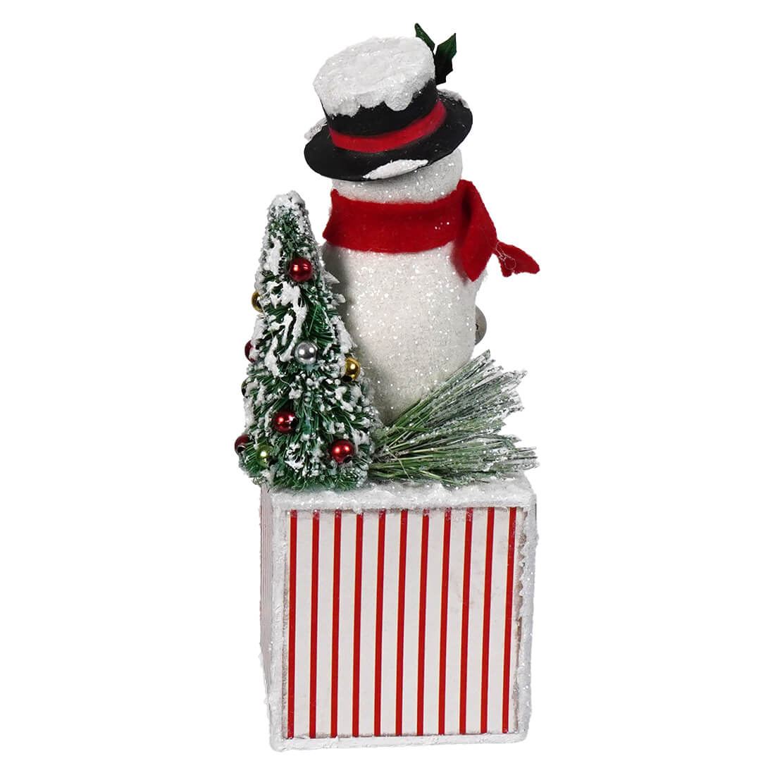 A bethany lowe designs bright snowman figurine with a glittery white body red scarf and black top hat beside a christmas tree