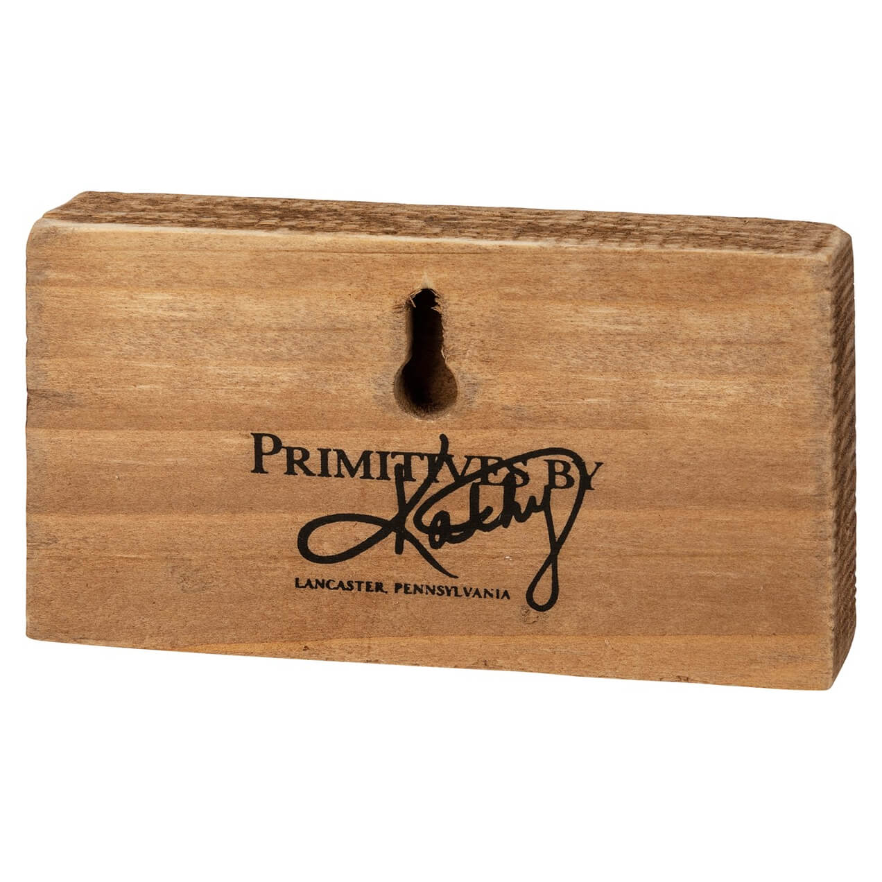 Wooden block with ’Primitives by Kathy’ engraved on it, from Lancaster, Pennsylvania.