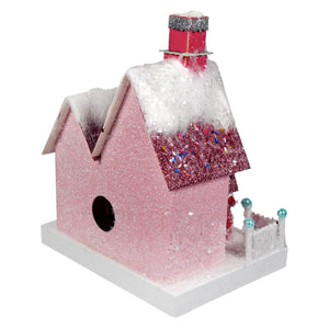 A pink glitter christmas house with a snowy roof and red sparkly chimney from cody foster merry holiday house