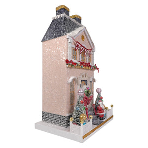 A merry manor festive pink glittered snowy christmas house figurine with black speckled roof and red garlands by cody foster
