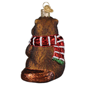 Brown glass merry marmot ornament shaped like a bear with a red white striped scarf and green fringe figural decor