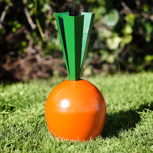 Orange carrot-shaped decorative object with geometric green leaves.