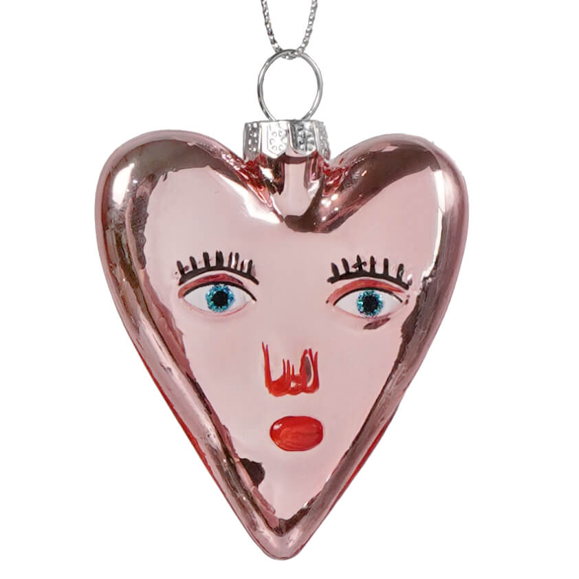 Mi amor heart glass ornament is a pink rose-gold heart ornament with a stylized face, perfect as a valentine’s day ornament