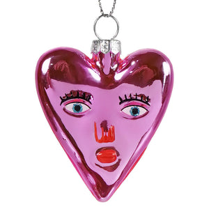 Mi amor heart glass ornament featuring a glossy pink heart ornament with a stylized face perfect for valentine’s day