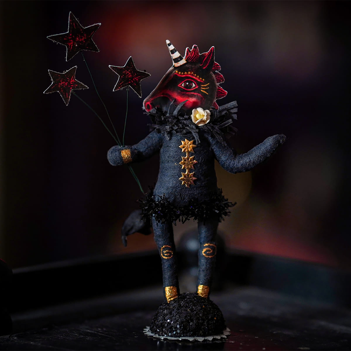 Dark blue textured fabric midnight unicorn figure with red face paint and gold stars by johanna parker